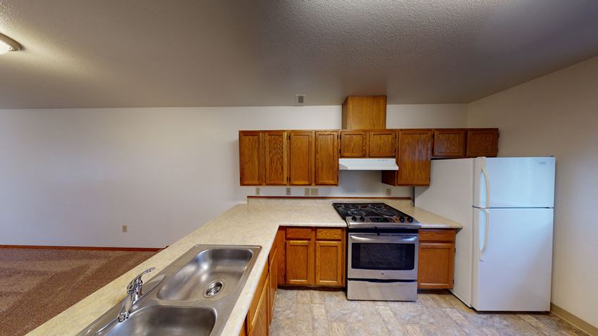 a kitchen with white appliances and wooden cabinets