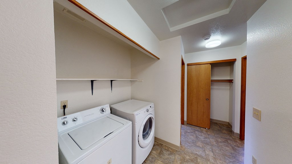 an empty laundry room with a washer and dryer in it