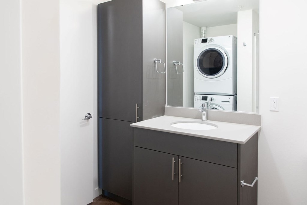 a bathroom with a sink and a washing machine in it