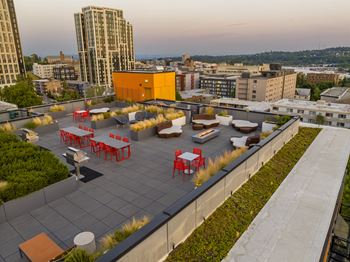 a roof deck with furniture and plants on top of a building