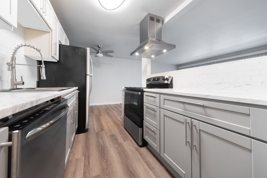 a kitchen with white cabinets and stainless steel appliances and a stove top oven