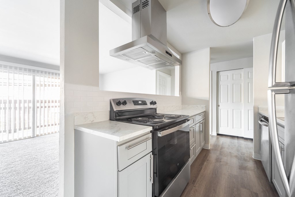 a kitchen with white appliances and a stove and a window