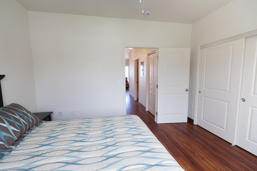 a bedroom with white walls and a bed with a blue and white comforter