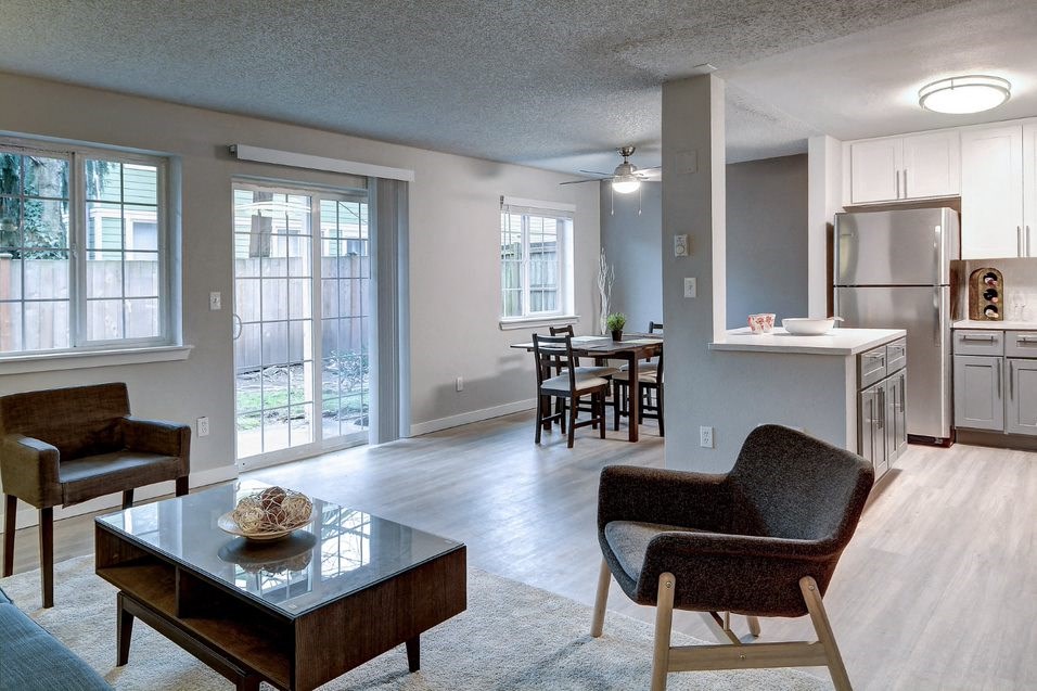 a living room and kitchen with a table and chairs