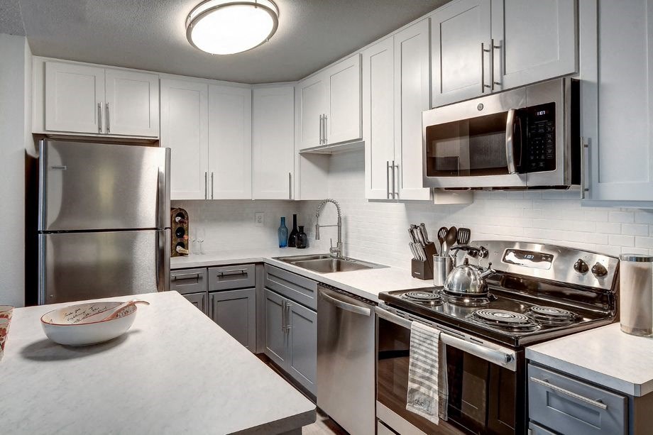 a kitchen with stainless steel appliances and white cabinets