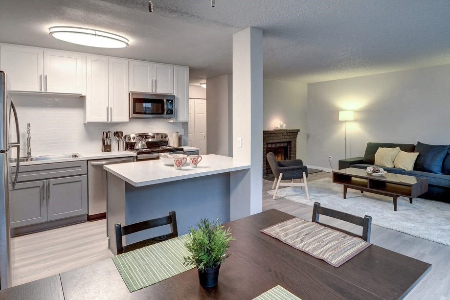 a living room with a kitchen and a table