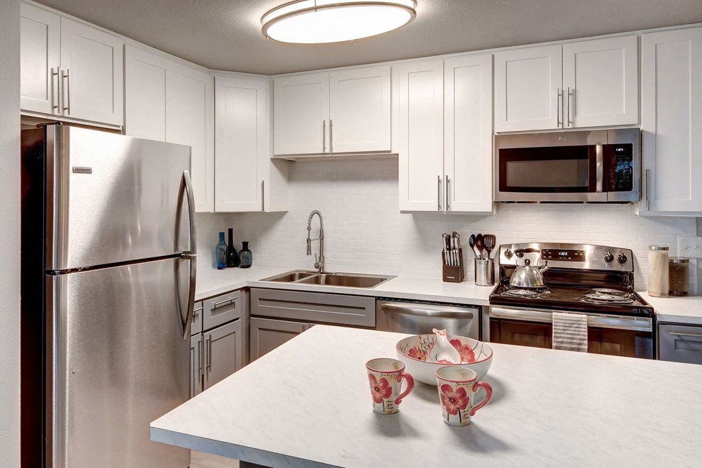 a kitchen with white cabinets and stainless steel appliances