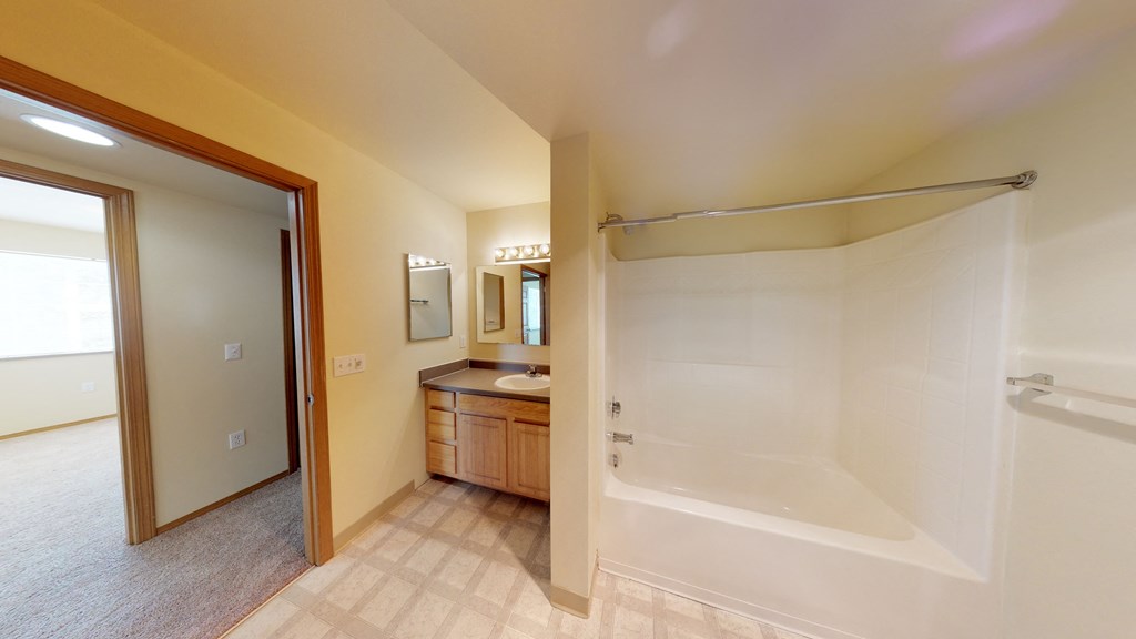 a bathroom with a shower and a sink and a mirror