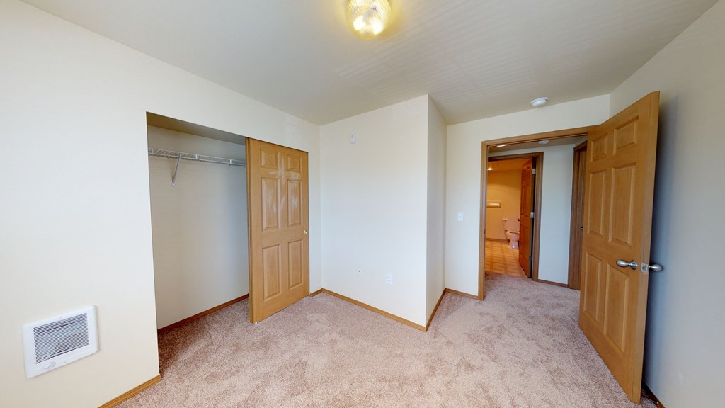 a bedroom with two closets and a door to a hallway