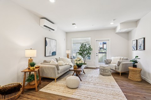 A well-lit, spacious living room with a variety of furniture and decor.