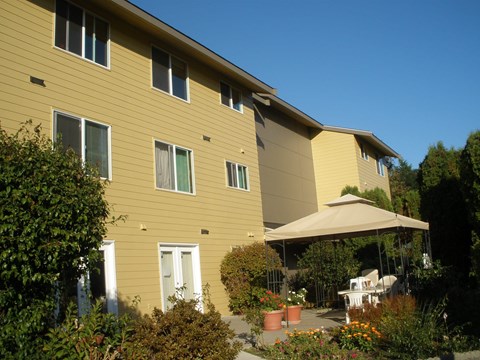 A yellow building with a patio and a canopy.