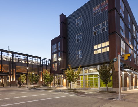 A modern building with a parking lot in front.