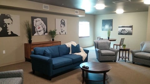 a living room with a blue couch and three chairs