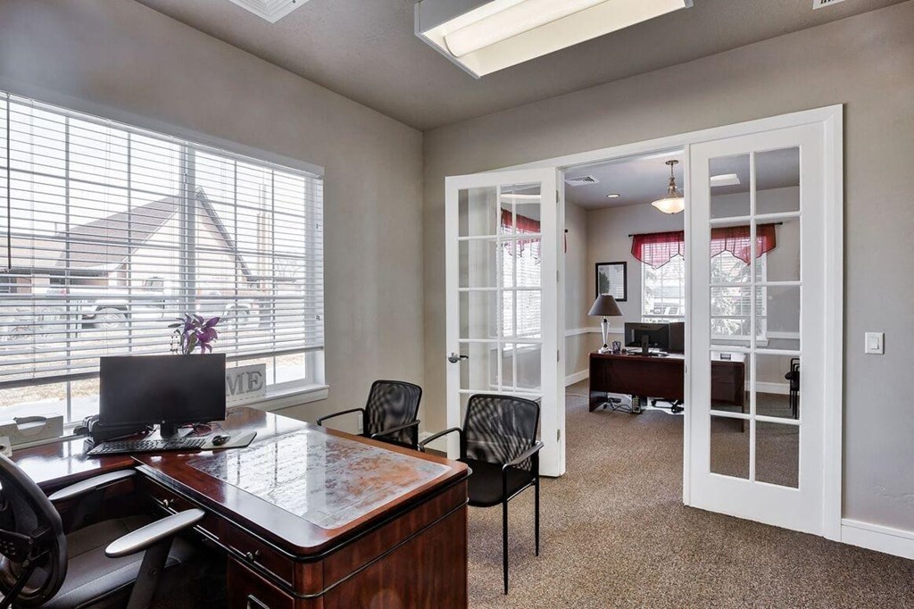 a home office with a desk and a window
