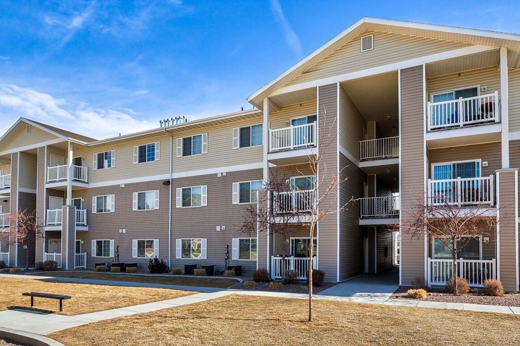 an exterior view of an apartment building with a picnic table