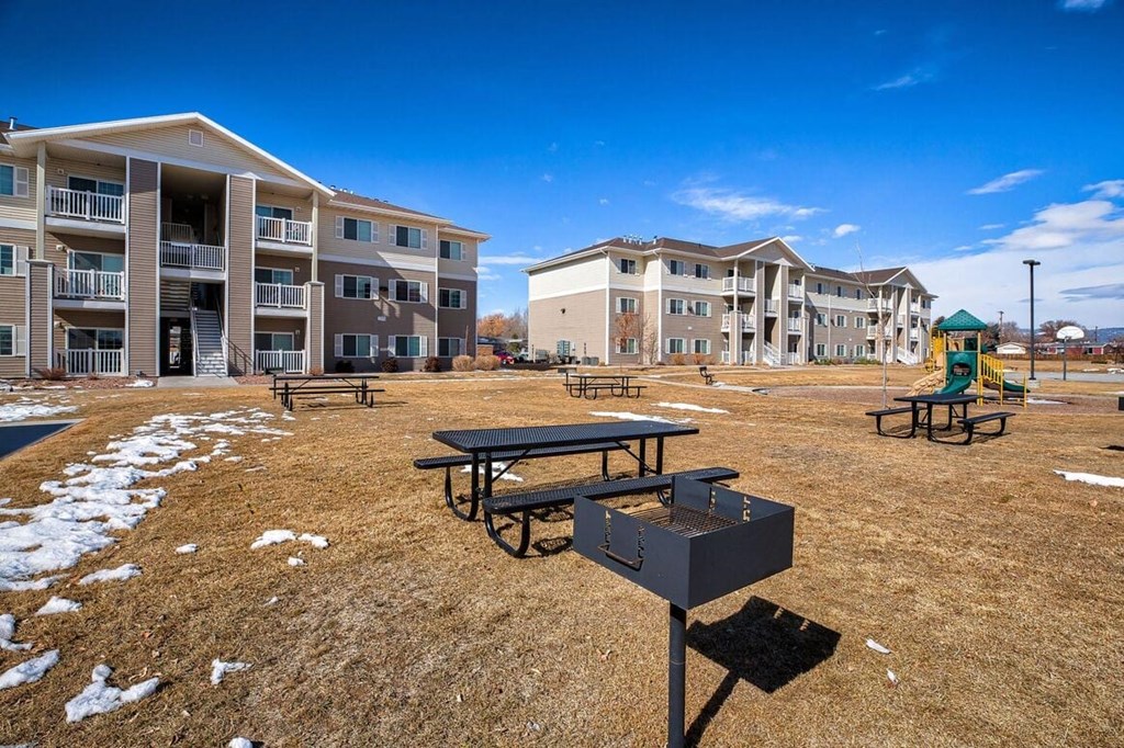 an apartment complex with picnic tables and a playground