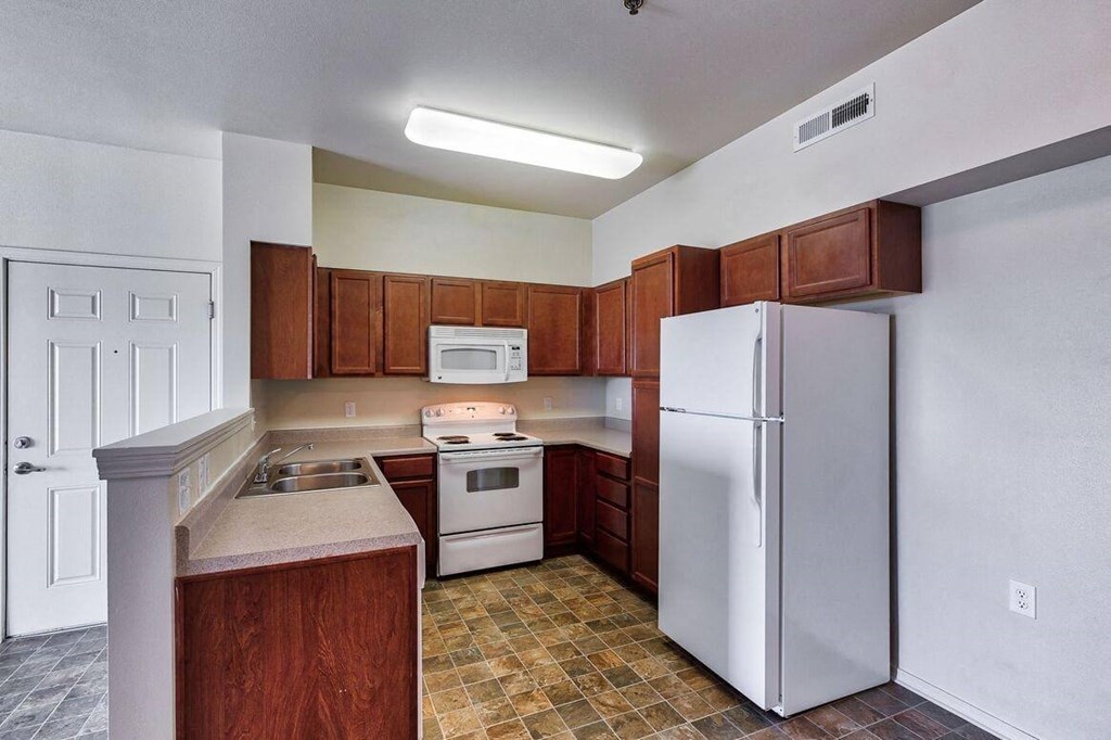 a kitchen with white appliances and wooden cabinets