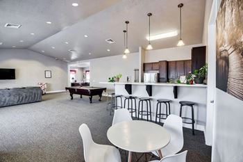 A modern open plan living and kitchen area with a grey carpet.
