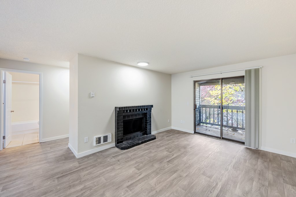 A room with a fireplace and sliding glass doors.