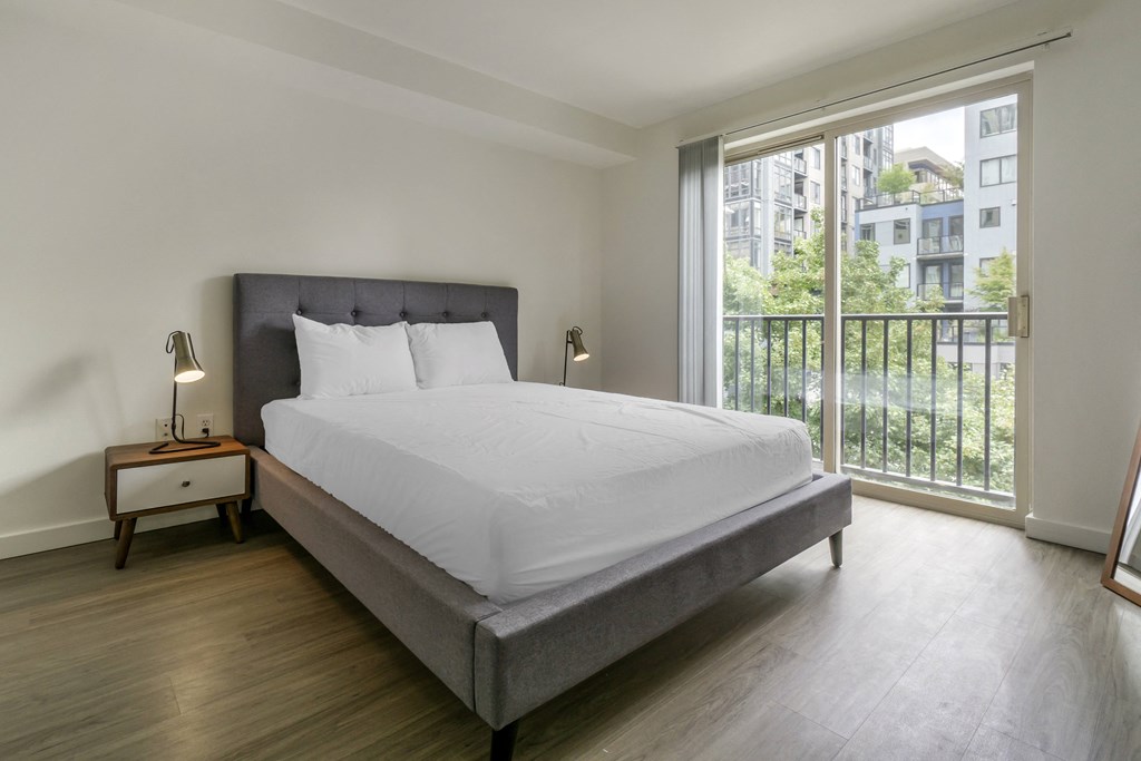 a bedroom with a bed and a large window