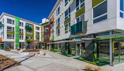 a building with green and white facade and a sidewalk