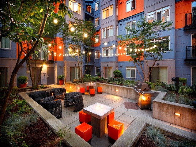 a courtyard with tables and chairs and lights in an apartment building