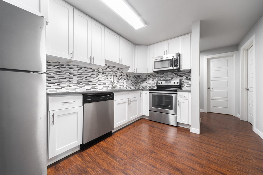 a kitchen with white cabinets and stainless steel appliances