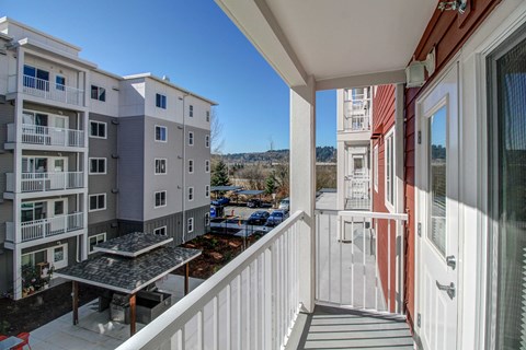 a balcony with a view of an apartment building and a table