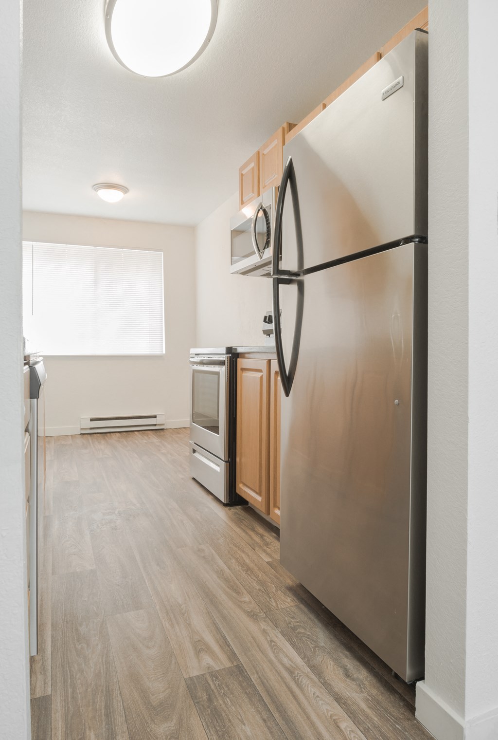 a renovated kitchen with stainless steel appliances and wood flooring
