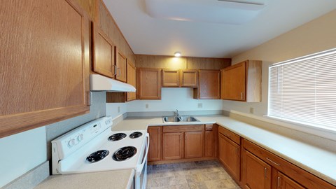 a kitchen with wooden cabinets and a stove and a sink