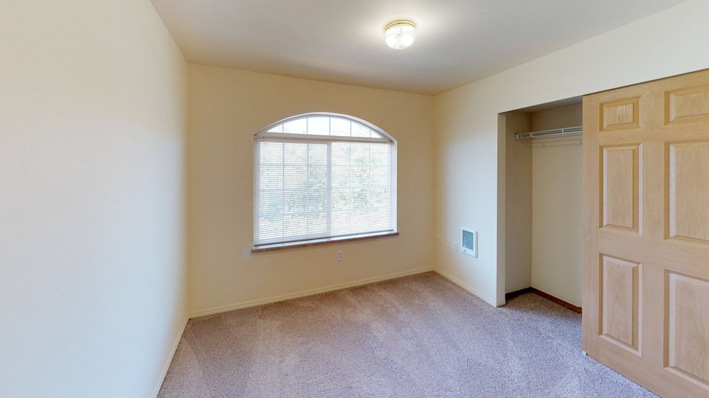 an empty room with a large window and a door