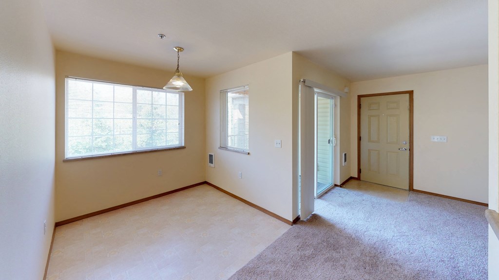 an empty living room with a door and a window