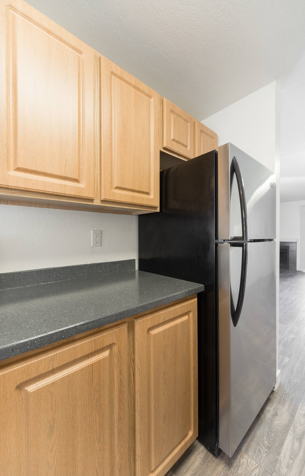 a kitchen with wooden cabinets and a stainless steel refrigerator