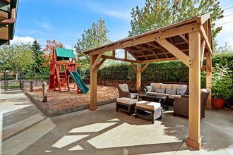 Outside lounge area with playground and BQ Grill for resident use. - Photo Gallery