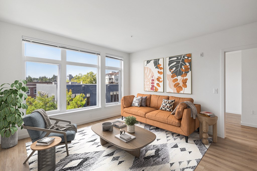 a living room with a brown couch and a large window
