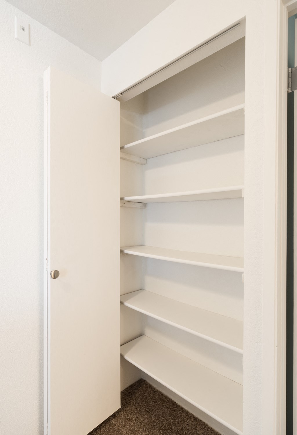 an empty closet in a small room with empty shelves