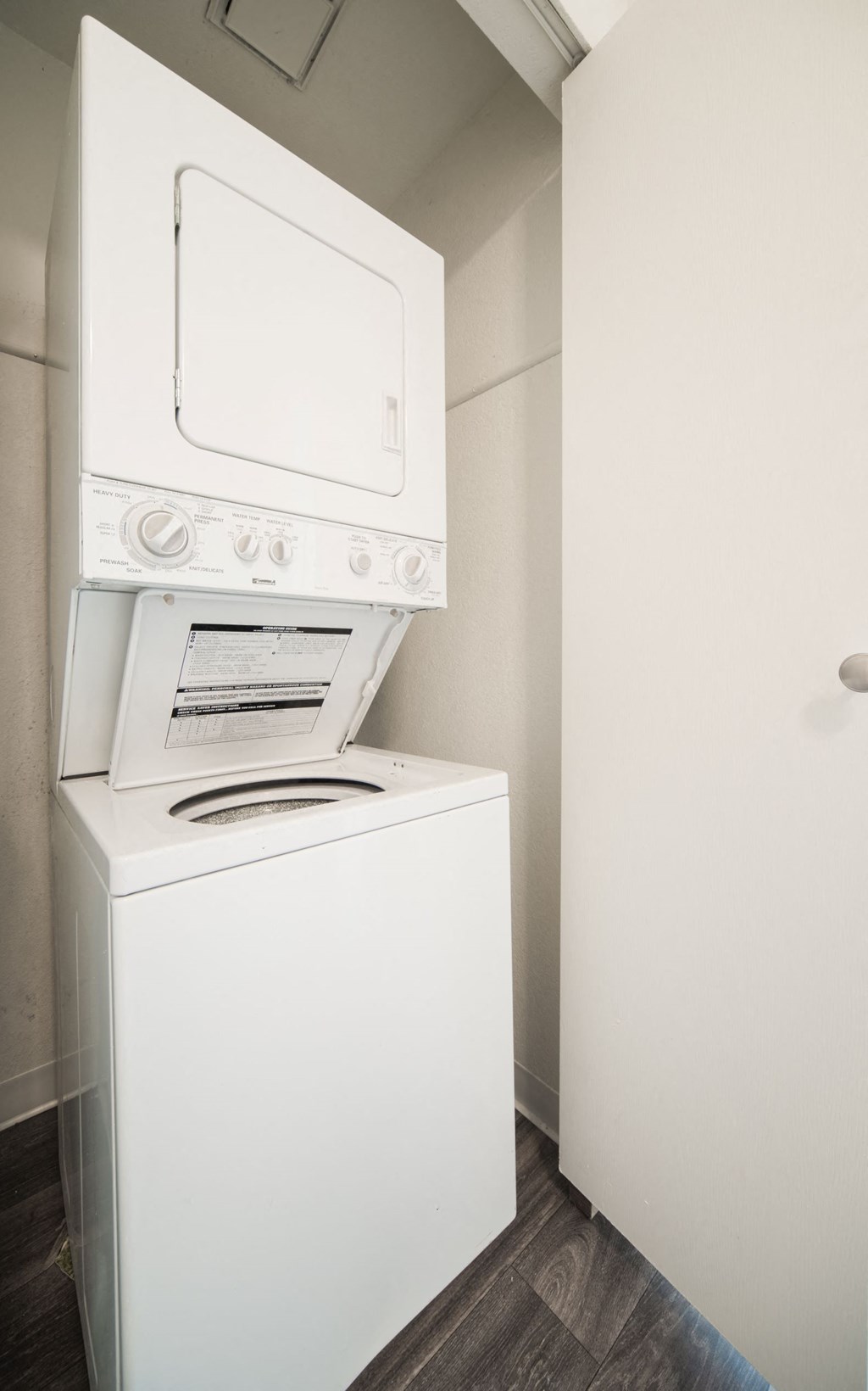 a washer and dryer in a room with white walls and wood floors