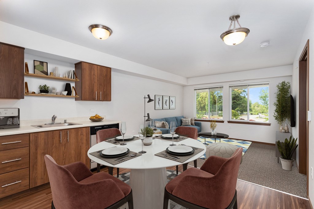 a living room with a white table and chairs and a kitchen with a large window