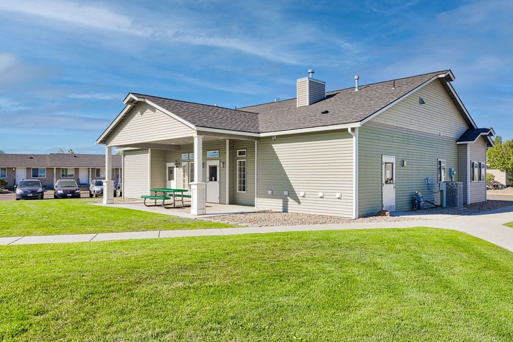 a white house with a porch and a green lawn