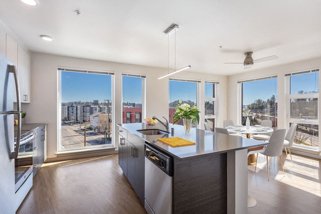 a kitchen and dining area with a large counter and windows