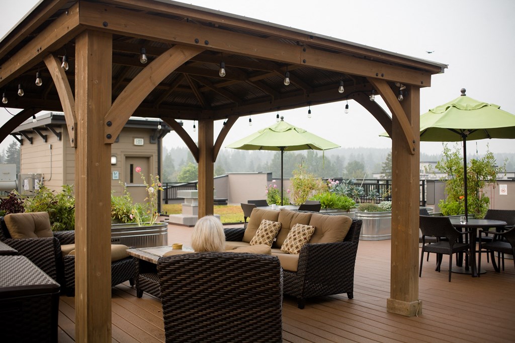 a woman sitting under a pavilion with patio furniture