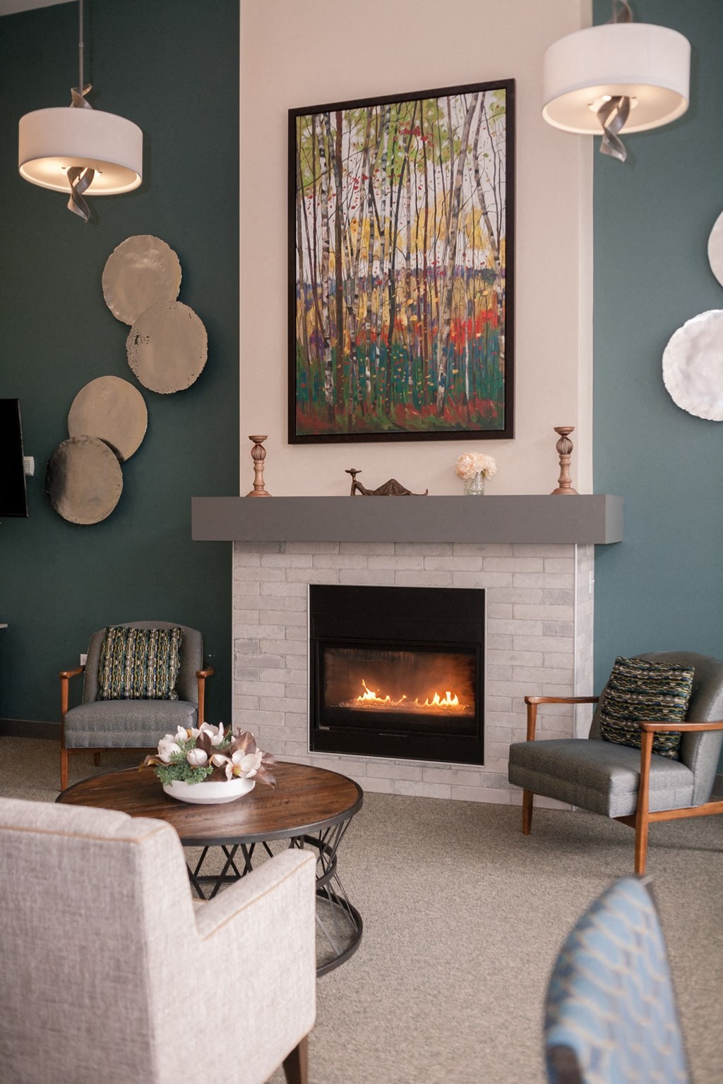 a living room with a fireplace and a painting on the wall
