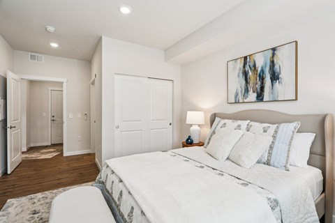 A bedroom with a large bed and a painting on the wall.