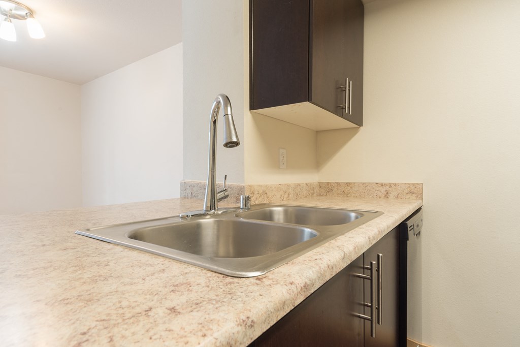 a kitchen with granite countertops and a stainless steel sink