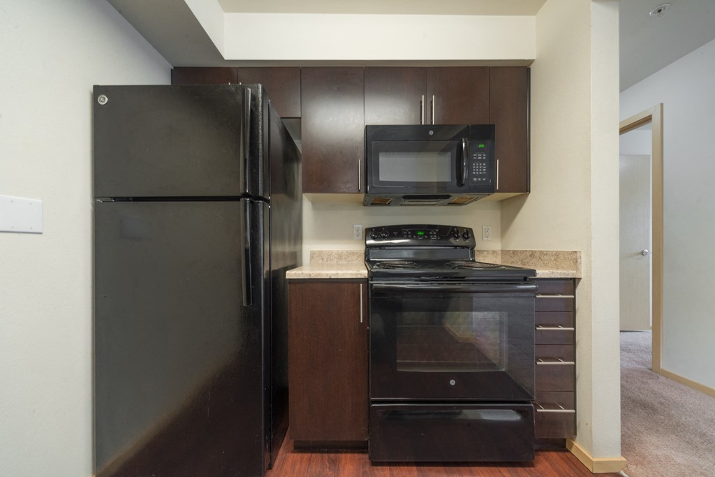 a kitchen with black appliances and brown cabinets