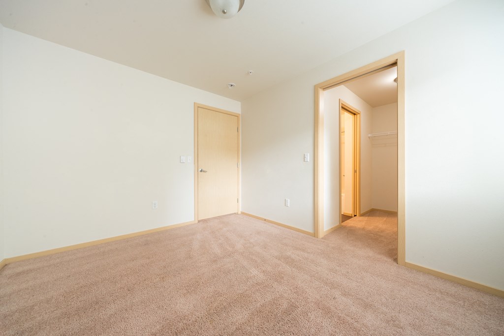 a bedroom with white walls and carpet