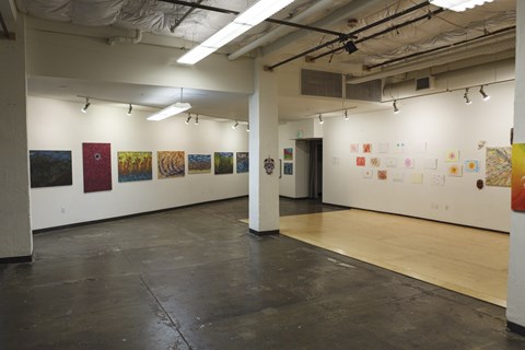 A room with a white wall and a painting on it.