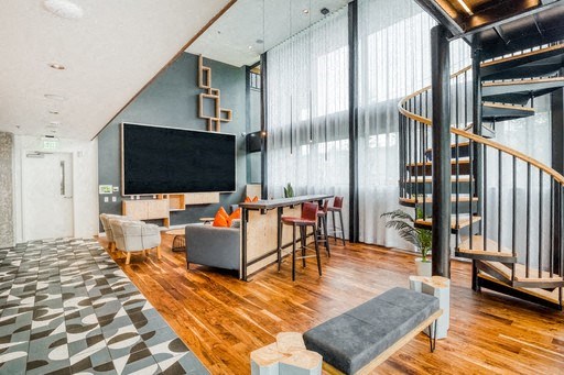 a living room with a staircase and a tv on the wall