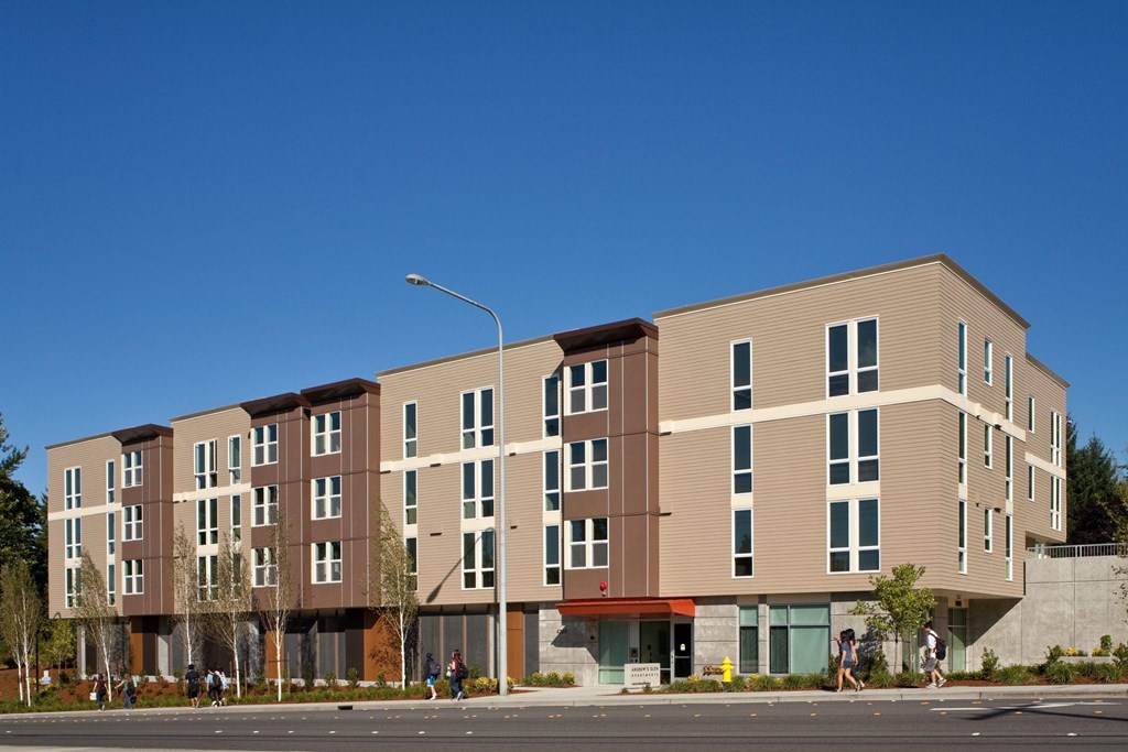 A modern apartment building with a mix of beige and brown facades.