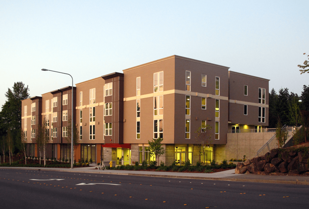 A large building with a lot of windows is lit up with yellow lights.